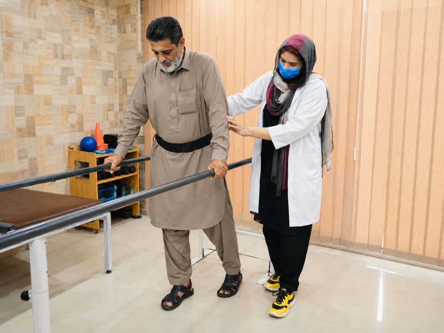 Physiotherapist assisting a man with walking and balance exercises during stroke rehabilitation