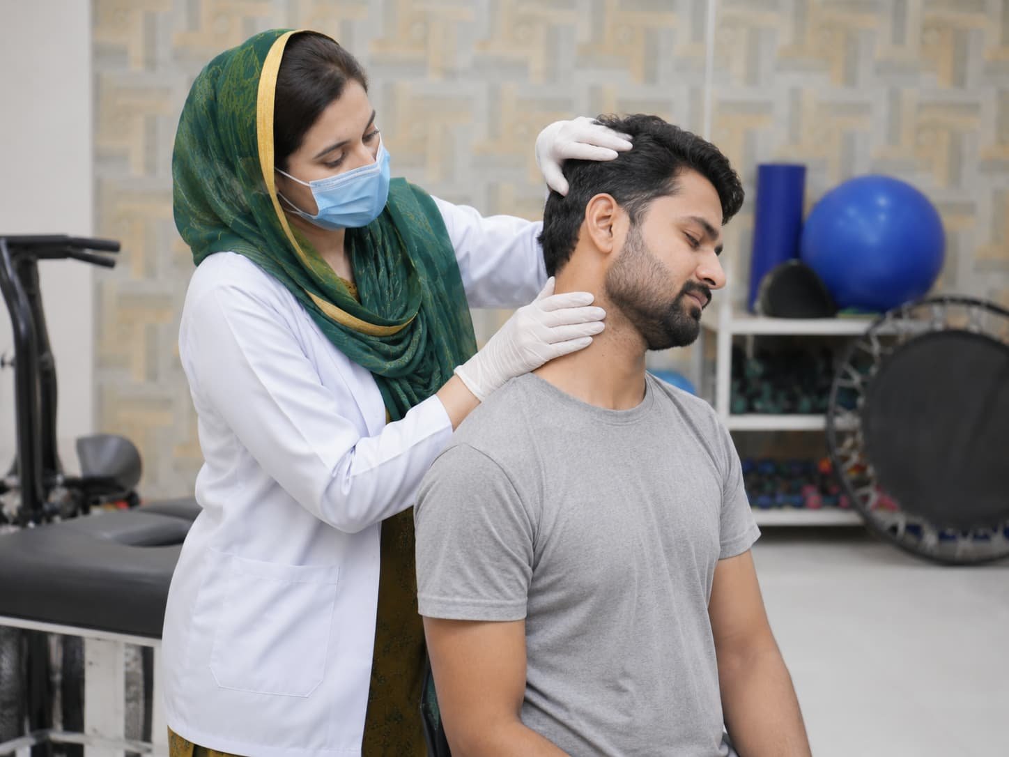 physiotherapist treating the neck of a male patient